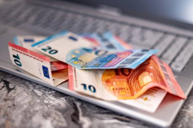 Laptop klavyesinde banknotlar. İnternet üzerinden mali işlemler