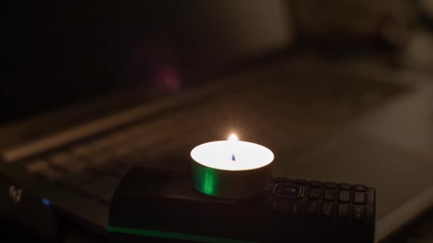 Eine Brennende Kerze Ein Telefon Und Ein Laptop Vor Dem — Stockvideo