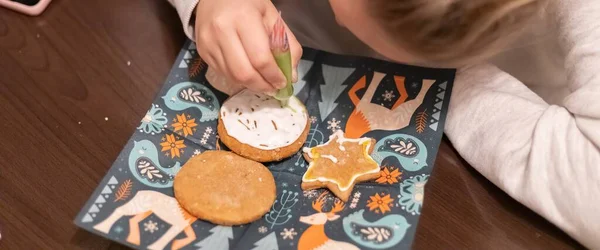 Children decorate cookies for New Year and Christmas