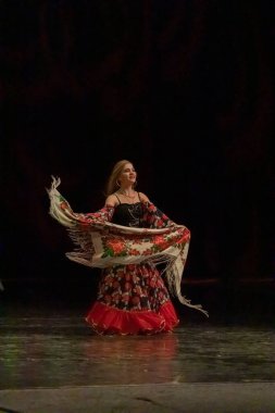 Ulusal elbiseli bir kız sahnede çingene dansı yapıyor.