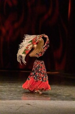 Ulusal elbiseli bir kız sahnede çingene dansı yapıyor.