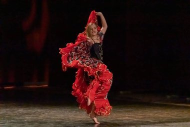 Ulusal elbiseli bir kız sahnede çingene dansı yapıyor.