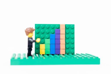 Sala, Slovakya - 01 12 2024: Ofis lego adamı satış büyüme tahtasının yanında duruyor.