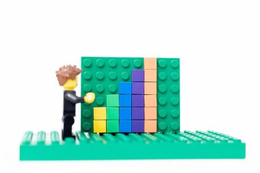 Sala, Slovakya - 01 12 2024: Ofis lego adamı satış büyüme tahtasının yanında duruyor.