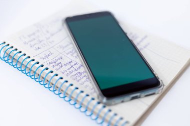 Okul çocuğunun not defterinde yeşil ekranlı bir akıllı telefon var. Ukrayna 'daki savaştan dolayı elektrikle ilgili sorunlar