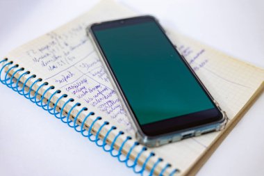 Okul çocuğunun not defterinde yeşil ekranlı bir akıllı telefon var. Ukrayna 'daki savaştan dolayı elektrikle ilgili sorunlar