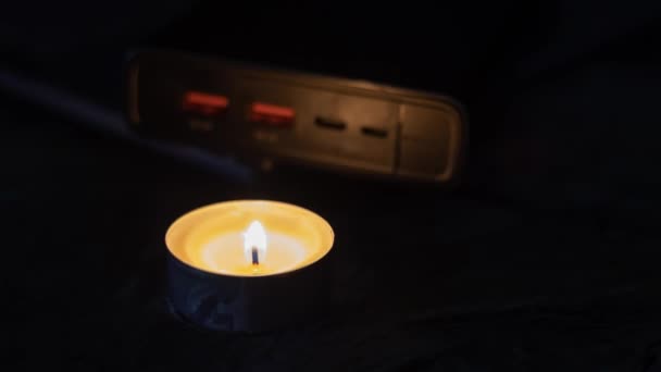 Brennende Kerze Der Nähe Der Powerbank Und Des Laptops Elektrizitätsprobleme — Stockvideo