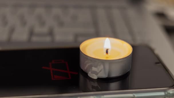 Brennende Kerze Auf Einem Entladenen Telefon Und Laptop Elektrizitätsprobleme Durch — Stockvideo