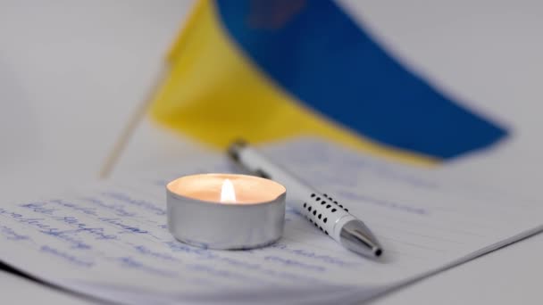 Hořící Svíčka Dětský Zápisník Pozadí Vlajky Ukrajiny — Stock video