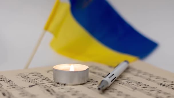 Burning Κερί Και Φύλλο Μουσικής Στο Παρασκήνιο Της Σημαίας Της — Αρχείο Βίντεο