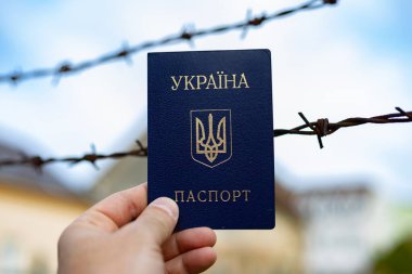 Ukrainian passport against the background of barbed wire. Violation of the law for the departure of citizens of the country clipart