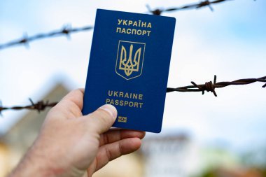 Ukrainian passport against the background of barbed wire. Violation of the law for the departure of citizens of the country clipart