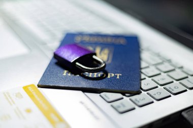 Ukrayna pasaportu ve dizüstü bilgisayarda asma kilit. Avrupa 'daki Ukraynalı mültecilerin haklarının kısıtlanması