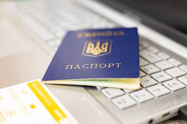 Laptop klavyesinde Ukrayna pasaportu. Avrupa 'daki Ukraynalı mültecilerin haklarının kısıtlanması