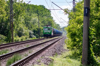 Tankları olan bir tren ormanda demiryolu boyunca gider.