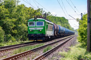 Tankları olan bir tren ormanda demiryolu boyunca gider.