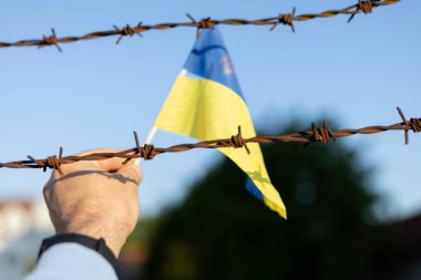 Ukrayna bayrağı ve dikenli teller. Ülkeden ayrılmayı yasakla. Kanun ihlali