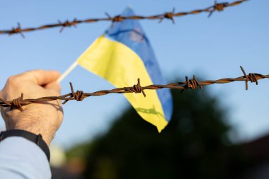 Ukrayna bayrağı ve dikenli teller. Ülkeden ayrılmayı yasakla. Kanun ihlali