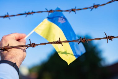 Ukrayna bayrağı ve dikenli teller. Ülkeden ayrılmayı yasakla. Kanun ihlali