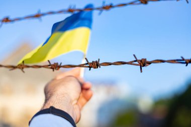 Ukrayna bayrağı ve dikenli teller. Ülkeden ayrılmayı yasakla. Kanun ihlali