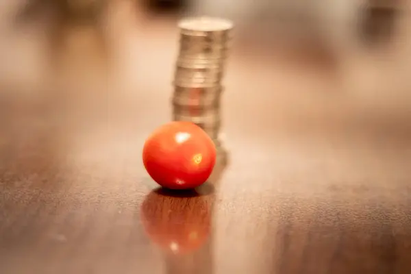 stock image Tomatoes and a stack of coins. Prices rise due to war in Ukraine