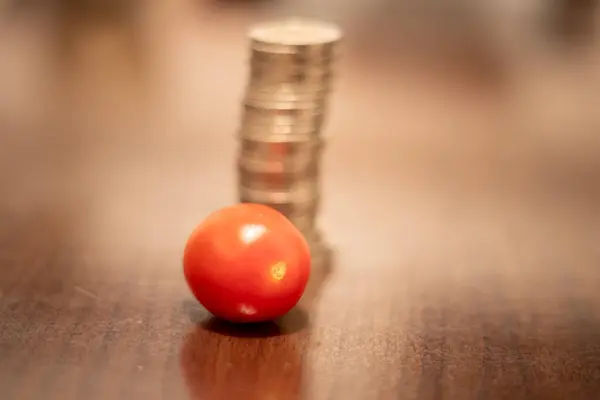 stock image Tomatoes and a stack of coins. Prices rise due to war in Ukraine