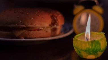 Mum ışığında yemek pişirmek. Tabakta hamburger ve mum. Ukrayna 'da savaş nedeniyle elektrik yok