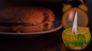 Mum ışığında yemek pişirmek. Tabakta hamburger ve mum. Ukrayna 'da savaş nedeniyle elektrik yok