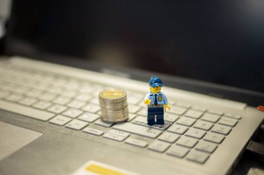 Oyuncak polis ve bozuk paralar dizüstü bilgisayarda. İnternet üzerinden mali işlemlerin korunması