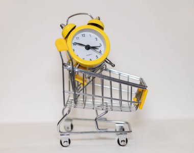 Tekerlekli sepetteki çalar saat.