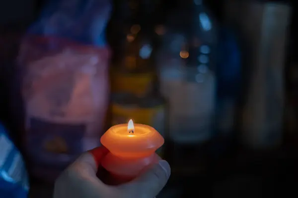 Karanlıkta mutfakta farklı yemek malzemelerinin yanında ellerinde mum yakmak. Ukrayna 'da savaş nedeniyle elektrik kesintisi