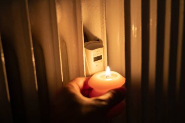 Isıtma bataryasının yanında yanan mum. Ukrayna 'da savaş nedeniyle ısı sorunları