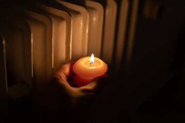 Isıtma bataryasının yanında yanan mum. Ukrayna 'da savaş nedeniyle ısı sorunları