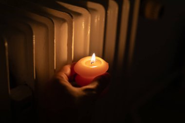 Isıtma bataryasının yanında yanan mum. Ukrayna 'da savaş nedeniyle ısı sorunları