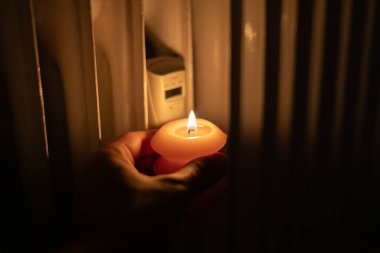 Isıtma bataryasının yanında yanan mum. Ukrayna 'da savaş nedeniyle ısı sorunları