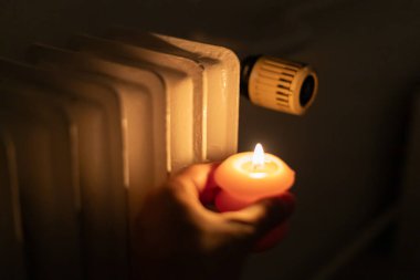Isıtma bataryasının yanında yanan mum. Ukrayna 'da savaş nedeniyle ısı sorunları