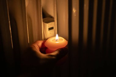 Isıtma bataryasının yanında yanan mum. Ukrayna 'da savaş nedeniyle ısı sorunları