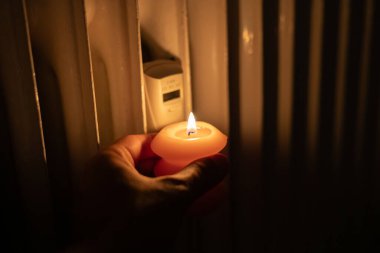 Isıtma bataryasının yanında yanan mum. Ukrayna 'da savaş nedeniyle ısı sorunları