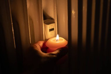 Isıtma bataryasının yanında yanan mum. Ukrayna 'da savaş nedeniyle ısı sorunları