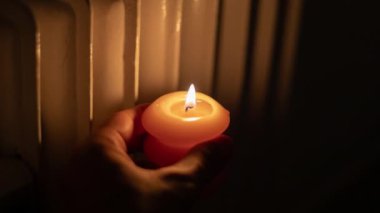 Isıtma bataryasının yanında yanan mum. Ukrayna 'da savaş nedeniyle ısı sorunları