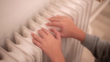 Çocuk elleri radyatörde. Ukrayna 'daki savaş nedeniyle ısıtma ve elektrik sorunları