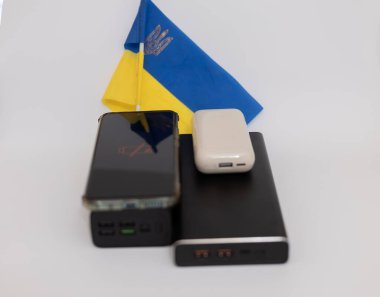 Güç bankaları ve telefonlar Ukrayna bayrağının arka planında. Ukrayna 'daki savaş nedeniyle elektrik kesintileri