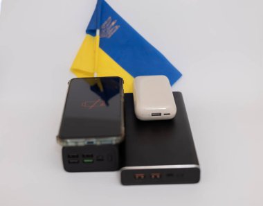 Güç bankaları ve telefonlar Ukrayna bayrağının arka planında. Ukrayna 'daki savaş nedeniyle elektrik kesintileri