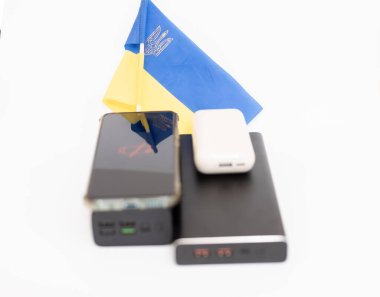 Güç bankaları ve telefonlar Ukrayna bayrağının arka planında. Ukrayna 'daki savaş nedeniyle elektrik kesintileri