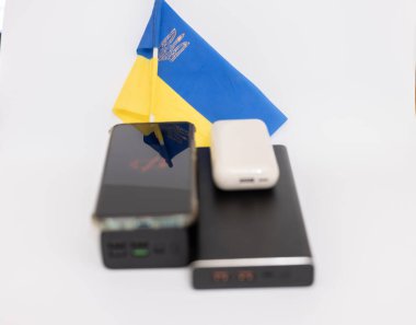 Güç bankaları ve telefonlar Ukrayna bayrağının arka planında. Ukrayna 'daki savaş nedeniyle elektrik kesintileri