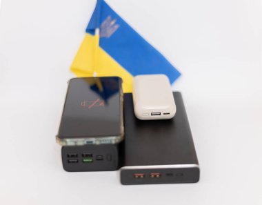 Güç bankaları ve telefonlar Ukrayna bayrağının arka planında. Ukrayna 'daki savaş nedeniyle elektrik kesintileri
