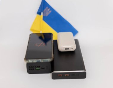 Güç bankaları ve telefonlar Ukrayna bayrağının arka planında. Ukrayna 'daki savaş nedeniyle elektrik kesintileri