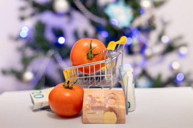 Sepette domatesler ve yeni yıl ağacının arka planına karşı banknotlar. Tatilden önce artan gıda fiyatları