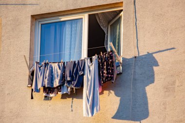 Çamaşırlar çok katlı bir binanın balkonunda kuruyor.