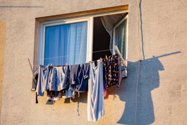 Çamaşırlar çok katlı bir binanın balkonunda kuruyor.